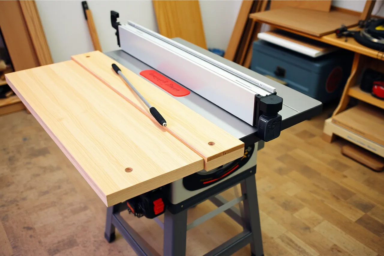 Table saw with guard fitted, push stick and feather board in place (Independent makers organize workshop layouts around stages, not stations)